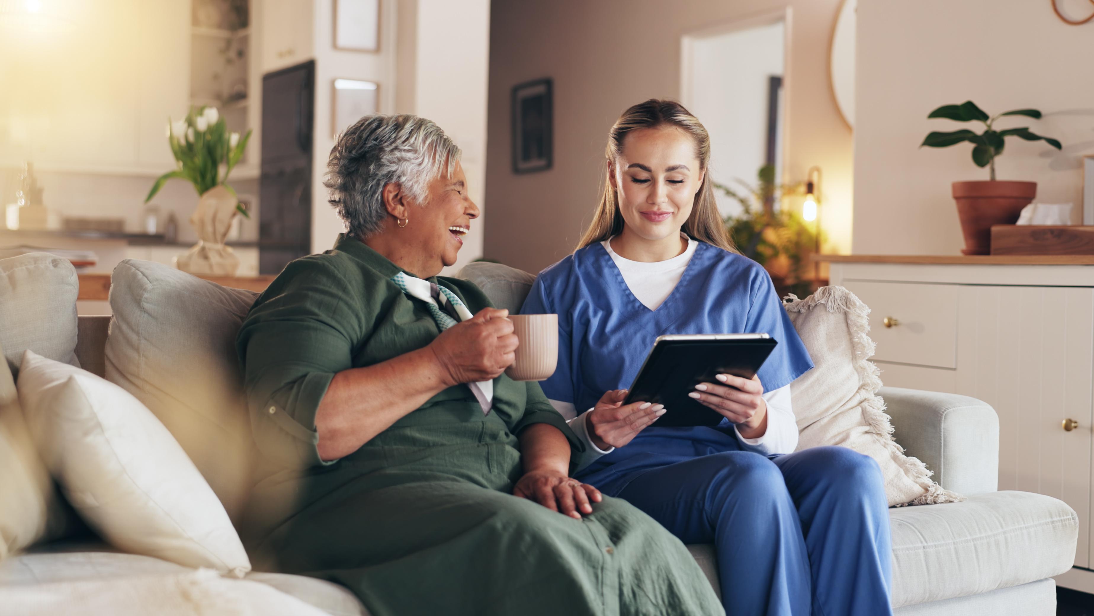 A travel nurse reviewing information with a patient in a furnished living room