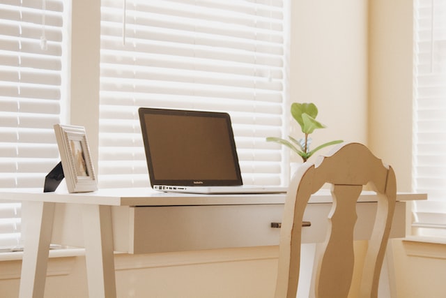 A workspace with a notebook, pen, and other items on a desk, likely used to illustrate the concept of remote work and renting.