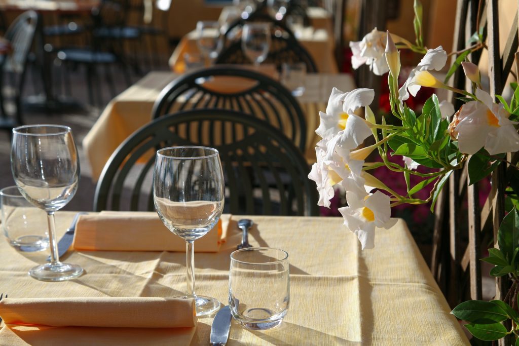 Discover the Best Restaurants in Logan Square, Chicago: A charming outdoor dining setup with elegantly set tables, complete with wine glasses and neatly folded napkins, complemented by beautiful white flowers creating a warm and inviting ambiance.