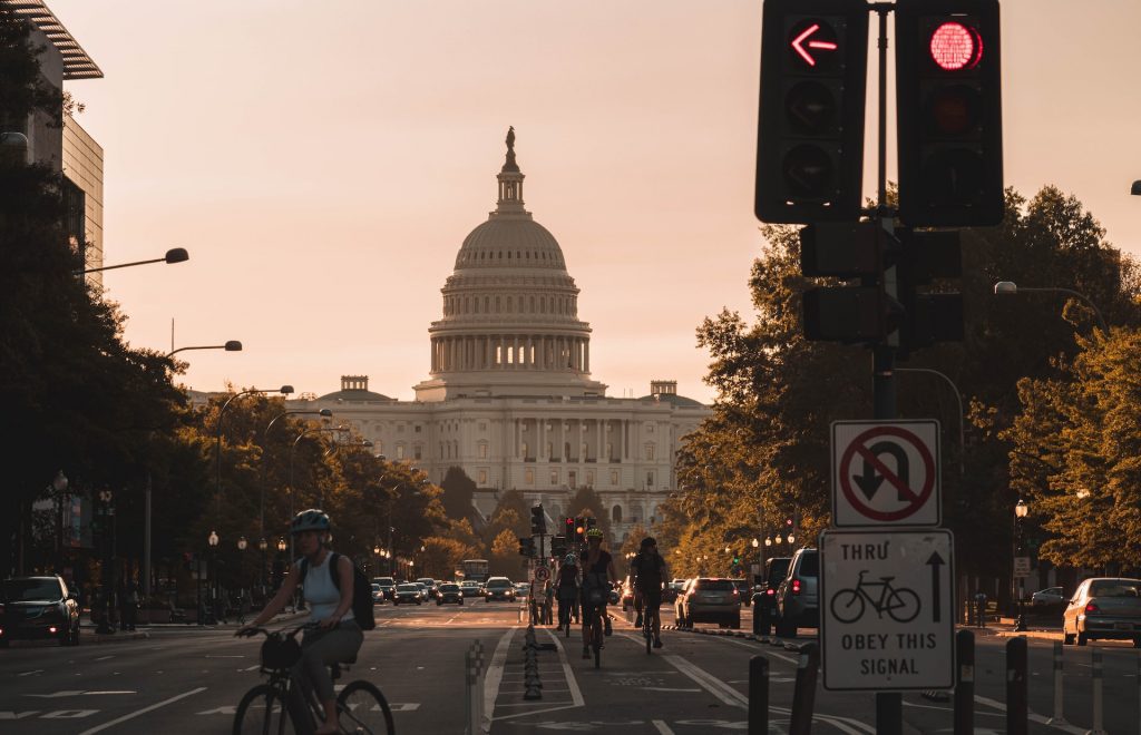 View of traffic and Capitol Hill with people biking on the road - Pros and Cons of Life in Washington D.C.
