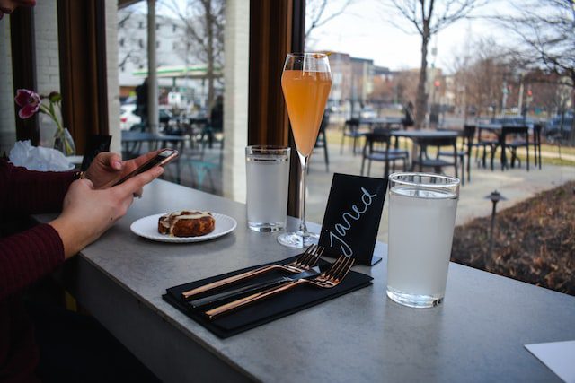 person holding smartphone near long-stem drinking glass photo Washington DC