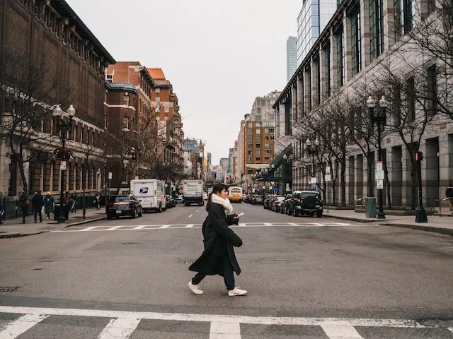 A photo of a girl crossing the road, representing the excitement and adventure of moving to a new city and the many things one needs to know before making the transition.