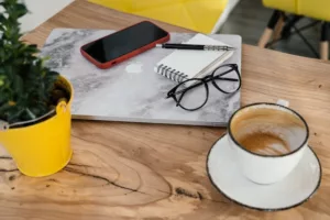 Modern gadgets placed on table with cappuccino in cafeteria