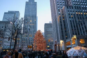 A photo of people walking near Manhattan buildings. While Manhattan is a bustling city, some neighborhoods are considered safer than others. Learn about the safest neighborhoods in Manhattan to ensure a secure living environment.