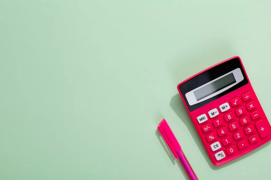 A pink calculator and pen, perfect for calculating rent increases