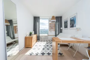 Elegant wooden furniture and stylish mirror in a room, illustrating furnished options for property rentals