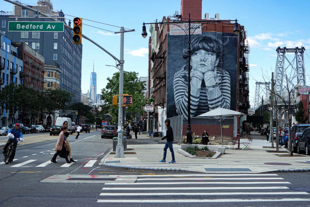 A woman crossing a street in front of a large painting photo – Brooklyn Image