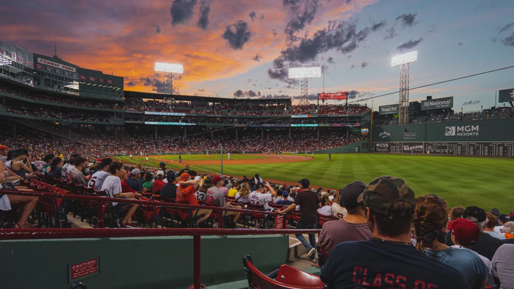 People enjoying a daytime Boston baseball game, representing leisure activities and associated costs in the city for the article 'The Truth About the Cost of Living in Boston