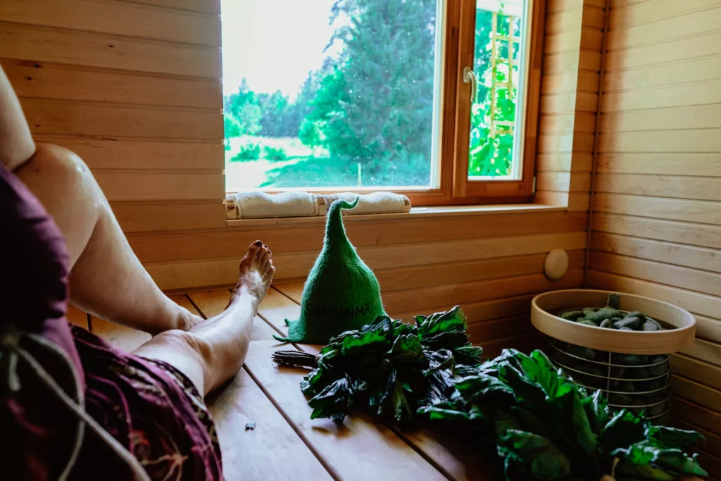 A person lying on a bed next to a window taking sauna