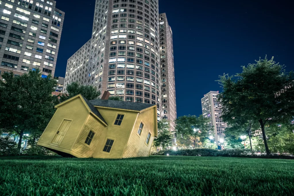 Yellow house on green grass overlooking buildings at nighttime photo
