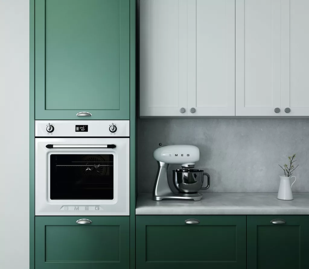 Modern kitchen design featuring a green cabinet, white SMEG oven and mixer, with a minimalist gray countertop and white vase with greenery.
