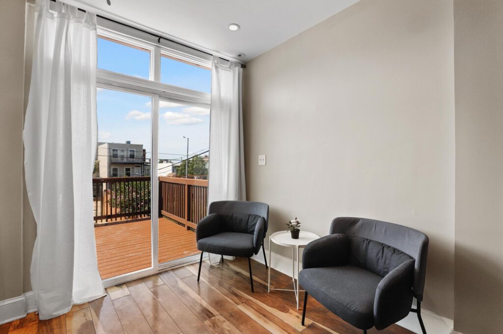 A cozy seating area in DC with two black chairs next to a large window, providing ample natural light and a view of the city.