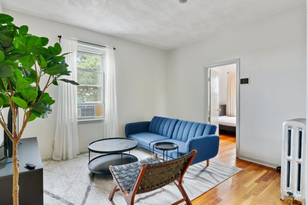 A comfortable living room in Chicago with modern furniture, a large plant, and natural light streaming through the windows.