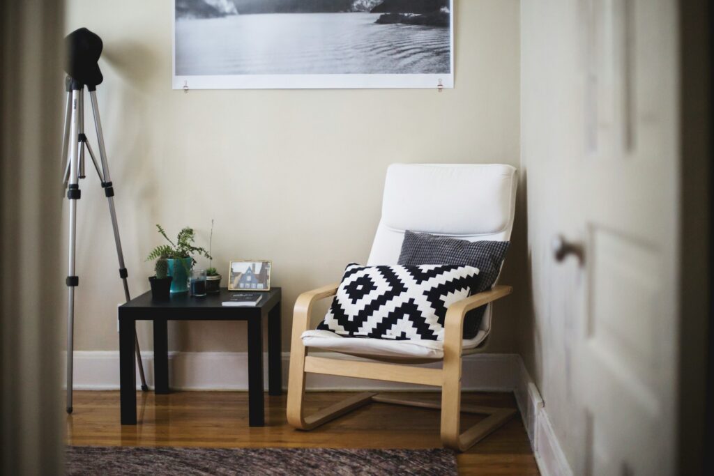 A cozy living room setup with a chair and side table, featured in the article 'Checklist For Moving Into A New Home: 7 Things To Remember.