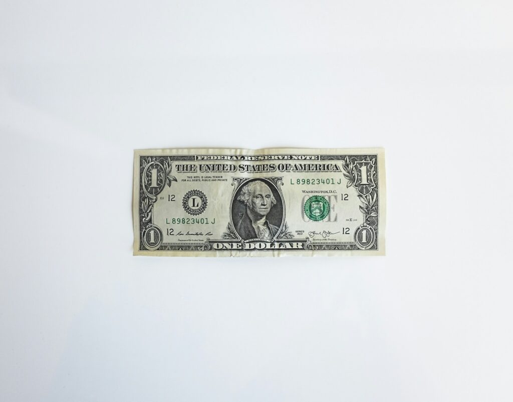 A single U.S. dollar bill on a white background, symbolizing potential hidden costs in rental agreements.