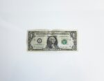 A single U.S. dollar bill on a white background, symbolizing potential hidden costs in rental agreements.