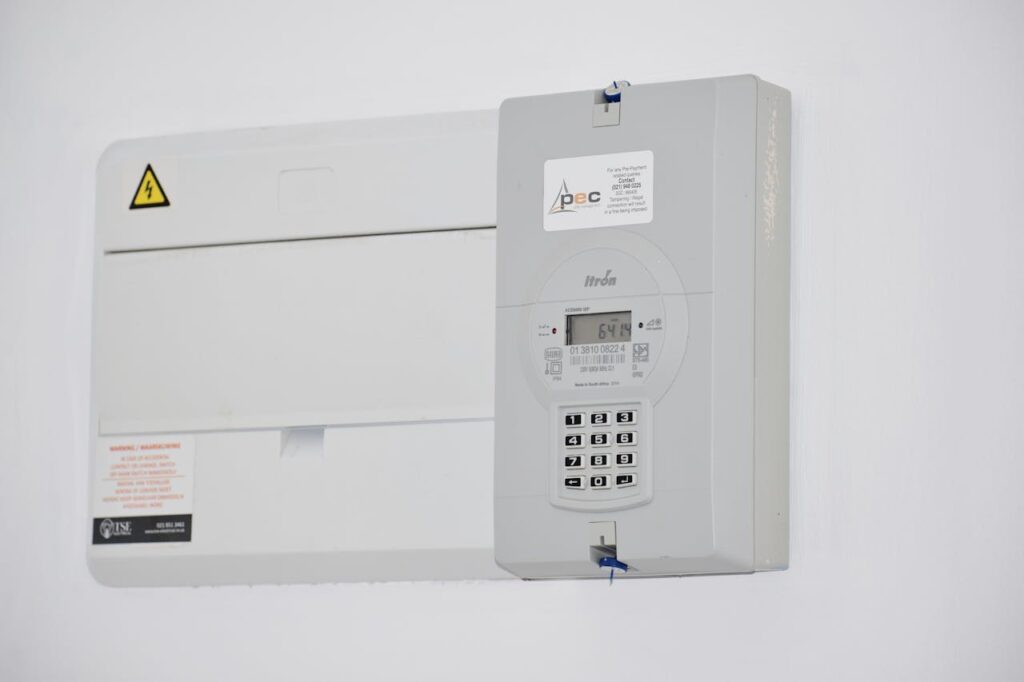 An electrical utility meter box mounted on a white wall, featured in the article titled 'Understanding Utilities In Your Apartment: What To Expect.