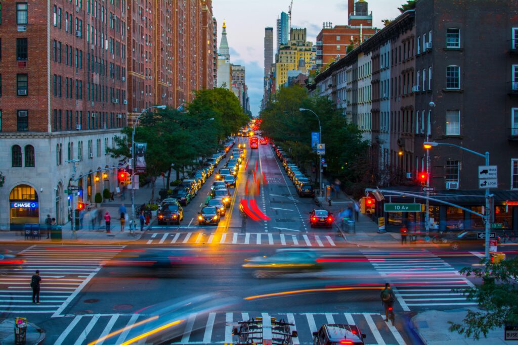 Vibrant city scene of New York's bustling traffic and iconic architecture at twilight.