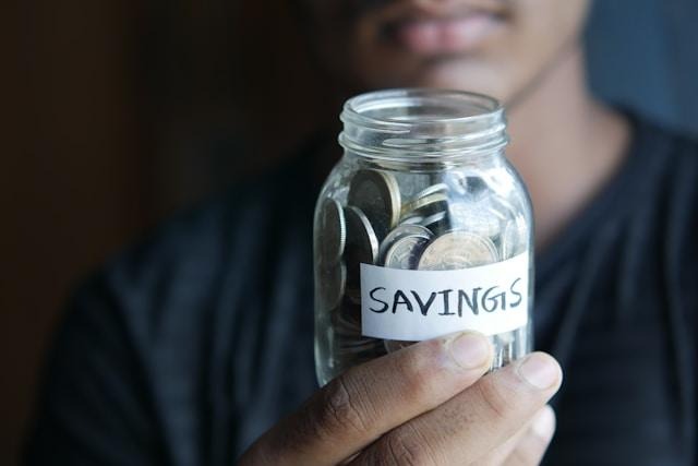 Person holding a jar with coins