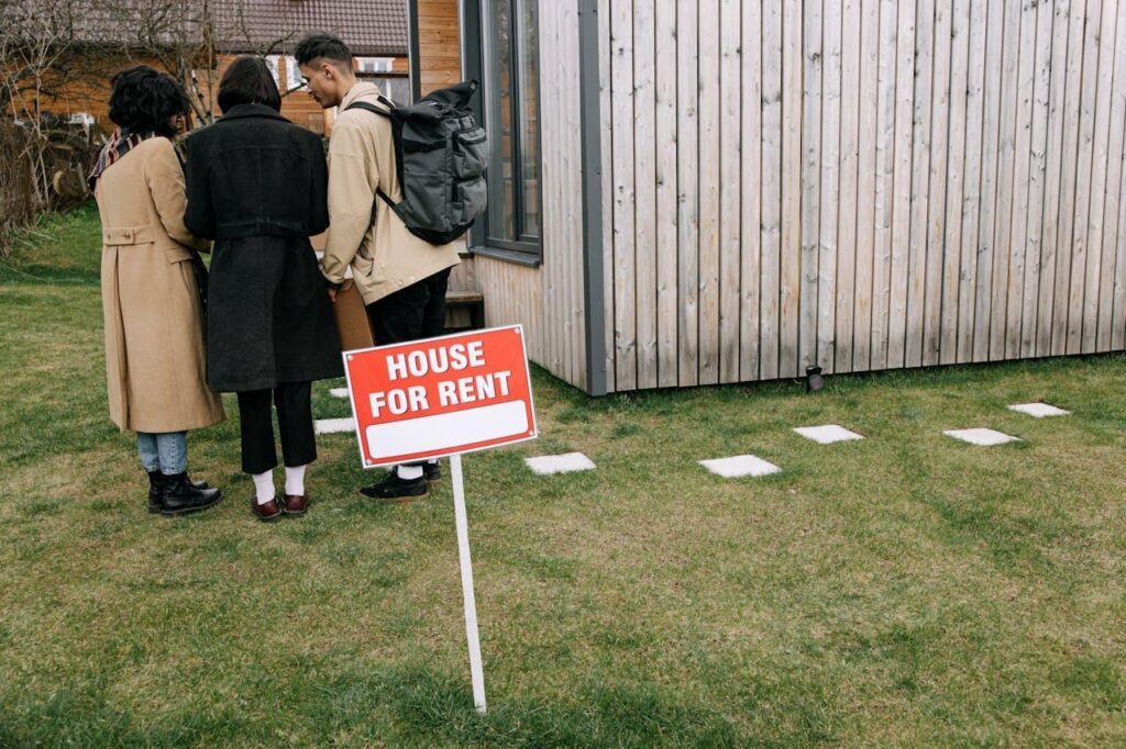 People standing near "House for rent" signage